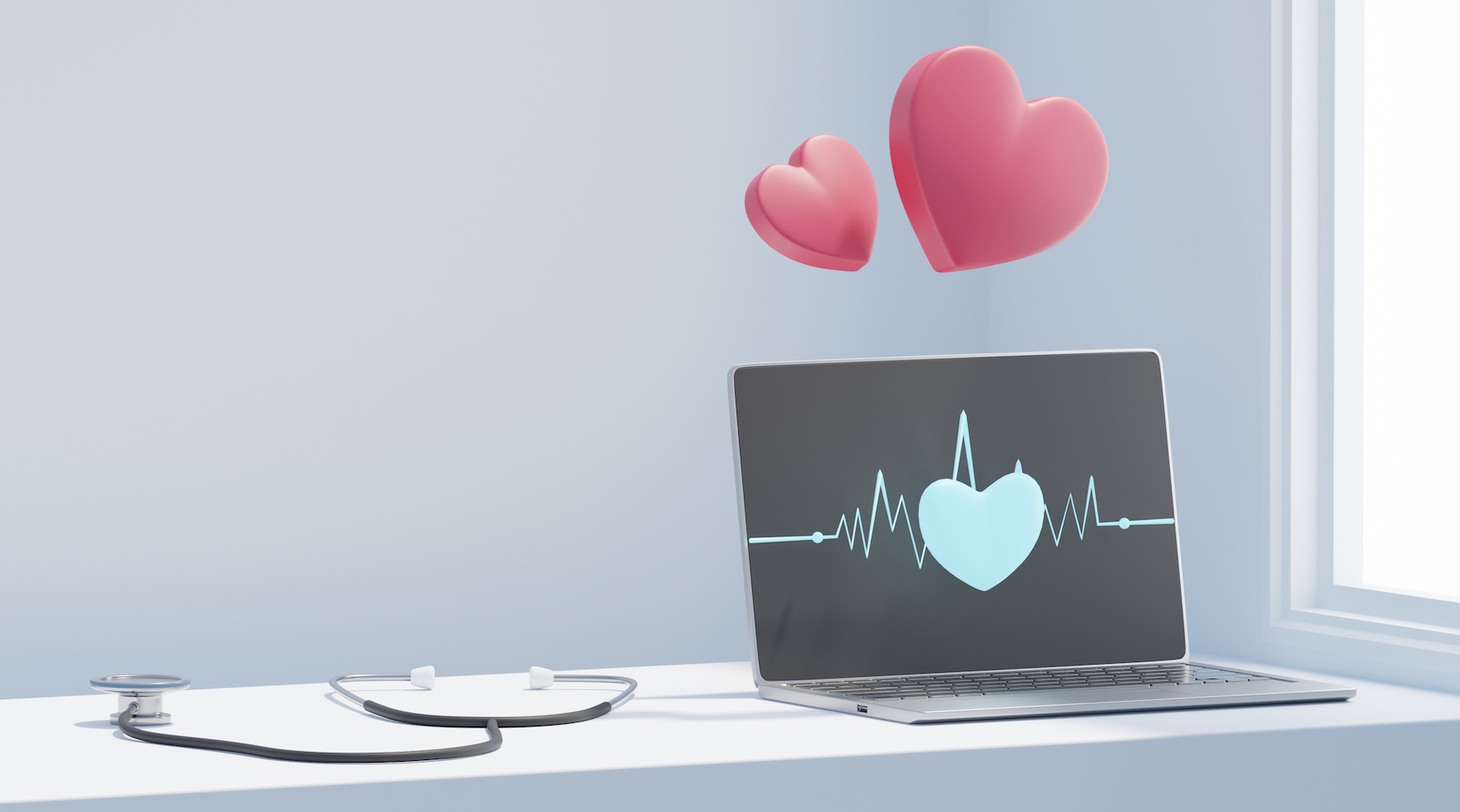 Stethoscope next to computer with 2 red hearts above and heartbeat line and heart on screen.