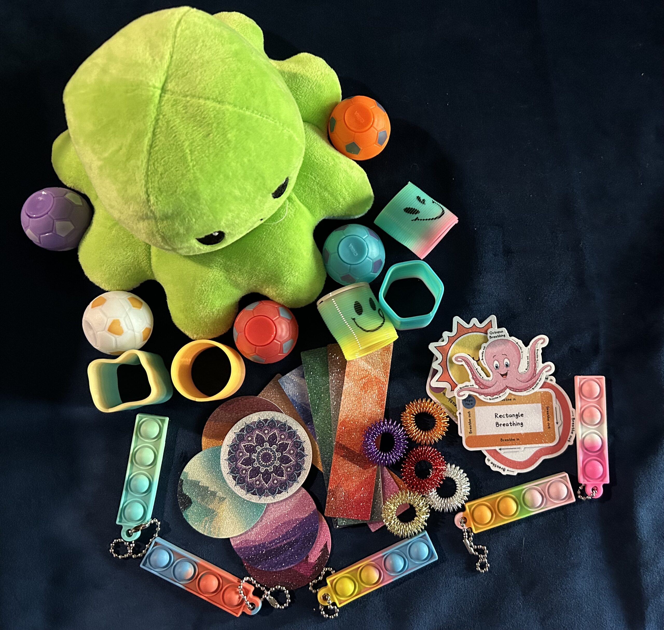 Selection of small sensory items with 1 medium on blue cloth.