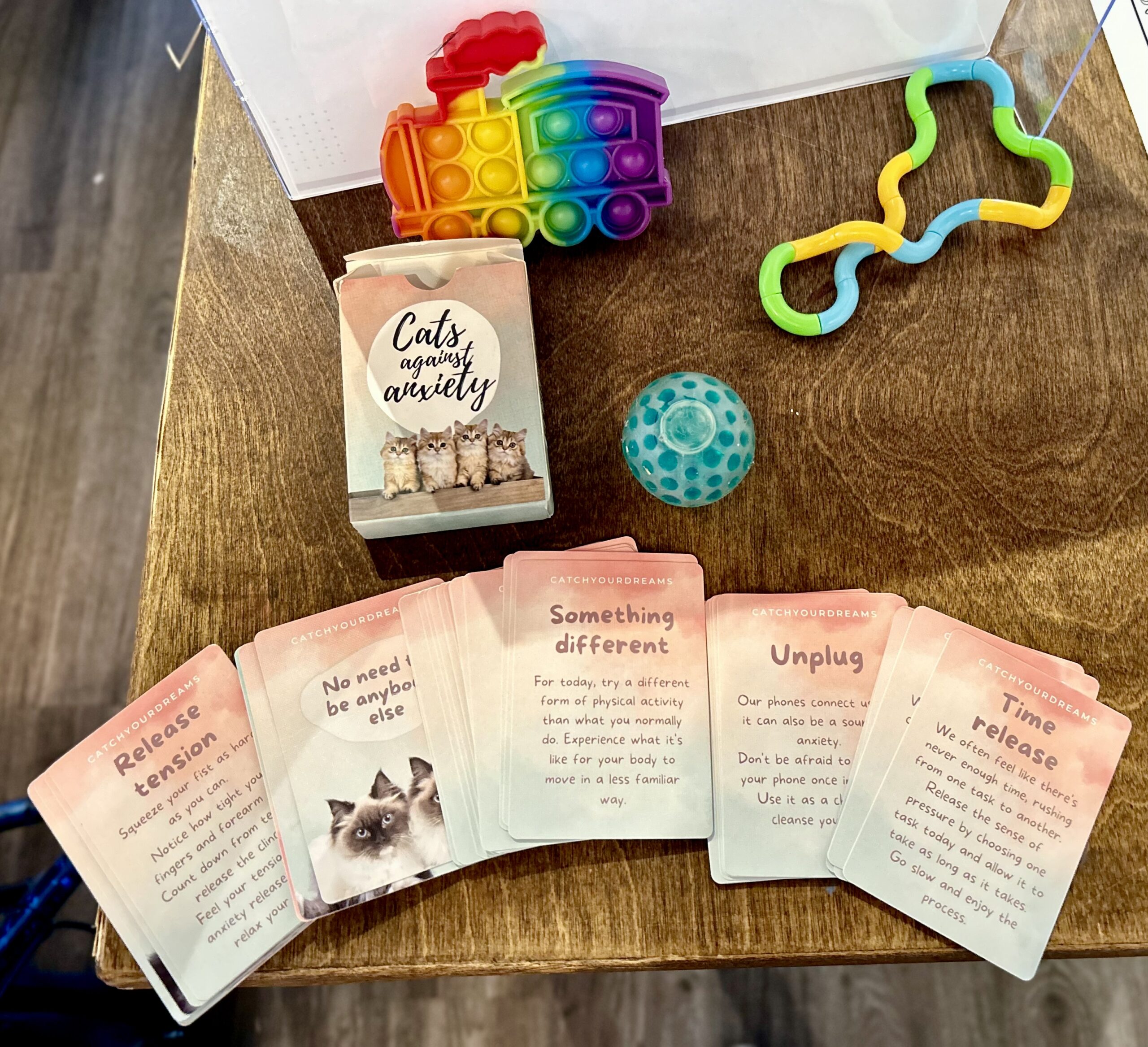 Stim toys and cards from a Cats Against Anxiety deck.